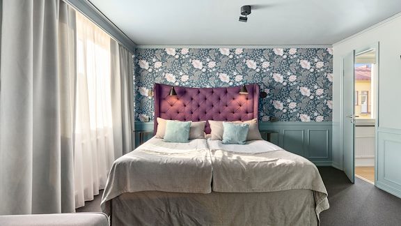 En dubbelsäng mot en vägg i ett hotellrum.