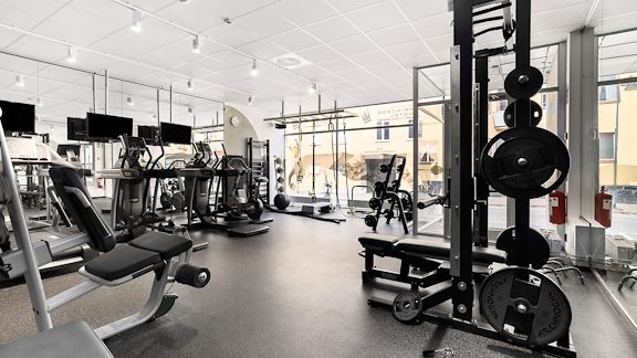 Ett hotellgym med olika cardiomaskiner och fria vikter.