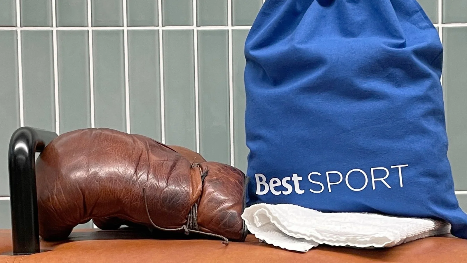 En boxningshandske i läder och en blå gymbag med texten "Best SPORT".